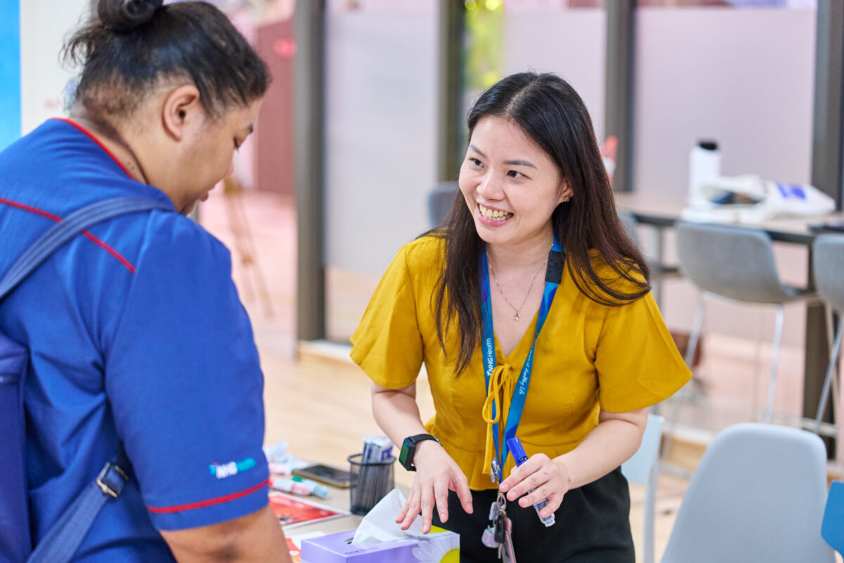 Candid engagement at a branded activation stand in Singapore