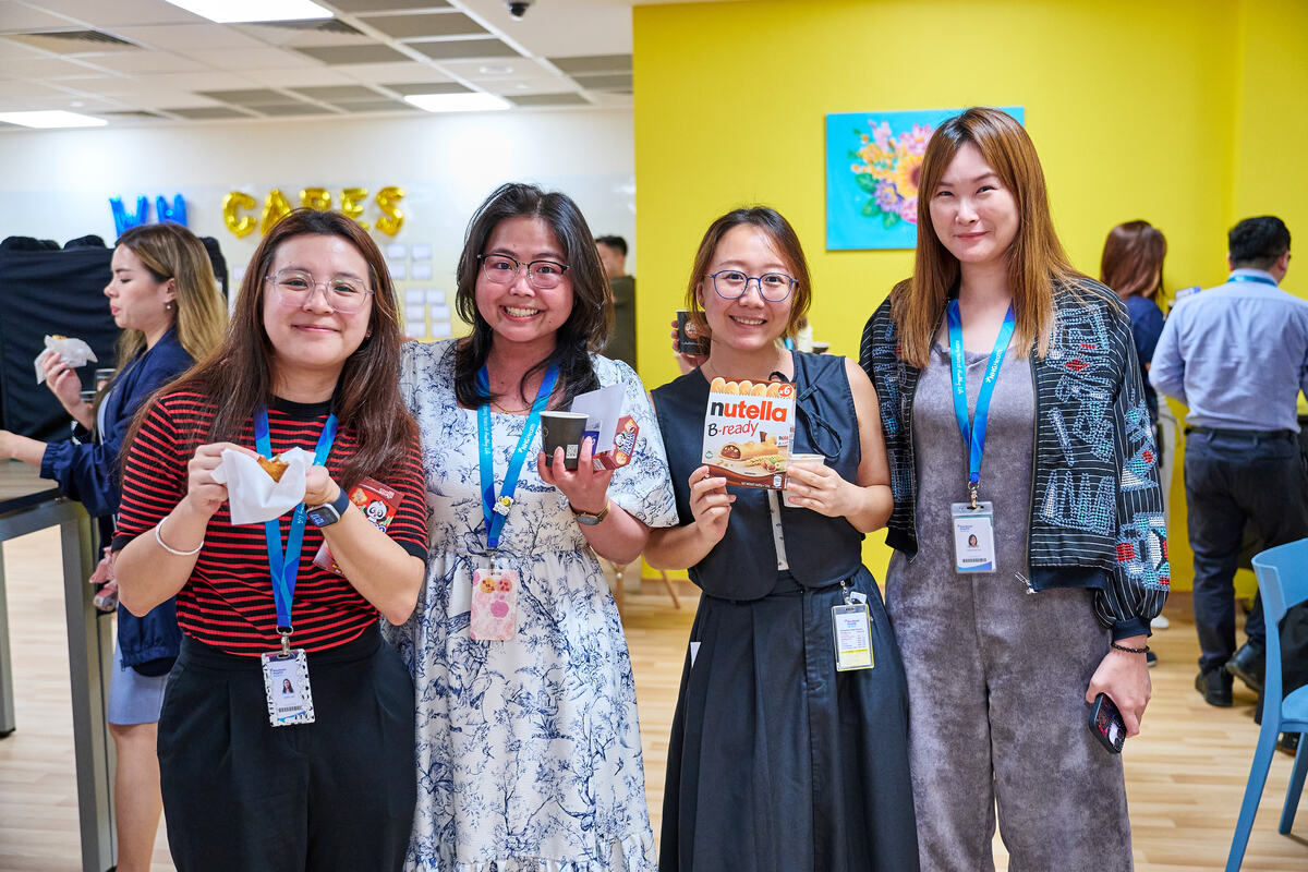 Four attendees holding their branded souvenirs at a Singapore brand activation