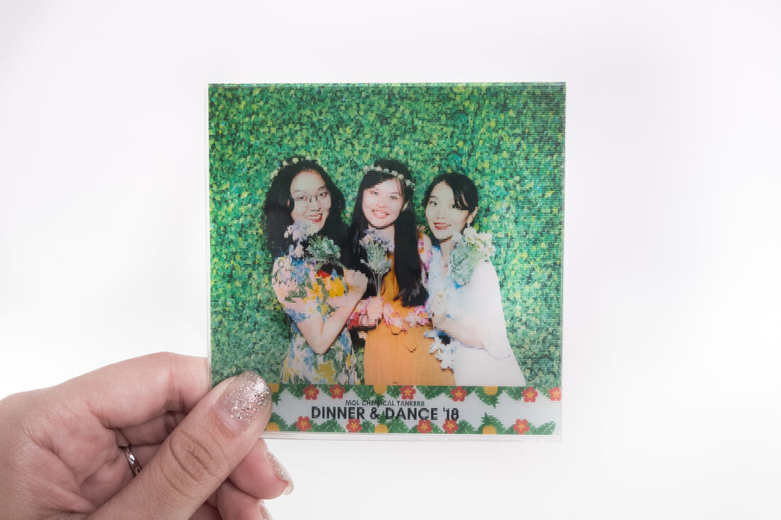 Lenticular GIF photobooth print held in hand, viewed from the first angle showing one frame