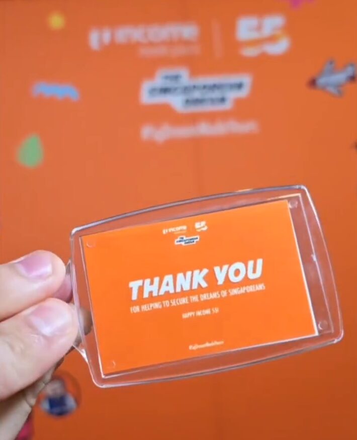 Branded photobooth keychain carrying a corporate logo, made live at a Singapore brand activation