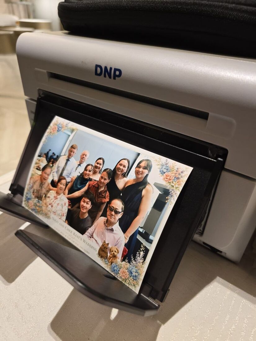 A dye-sublimation printer producing instant prints at a Singapore event