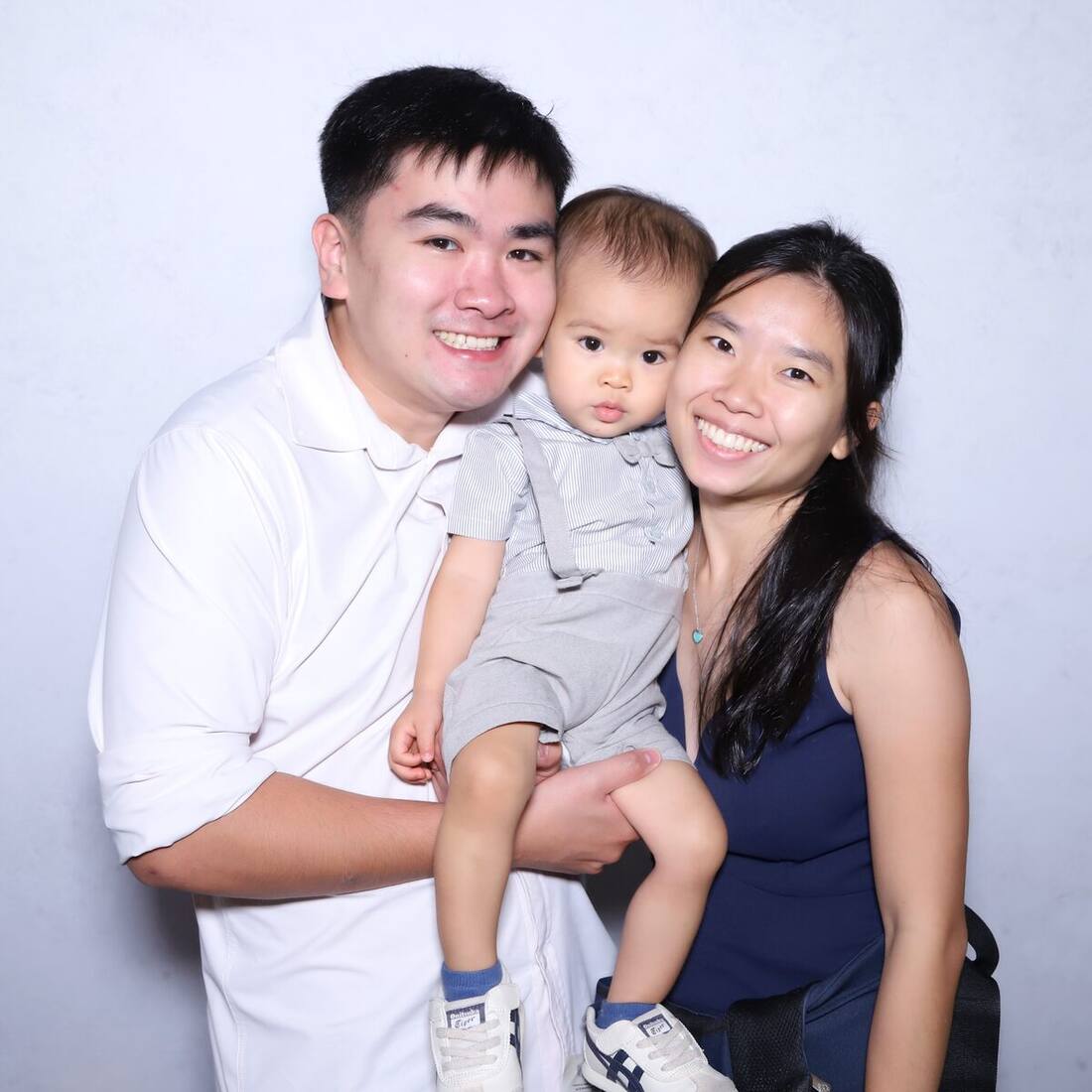 A young family enjoying a photobooth at a Singapore celebration